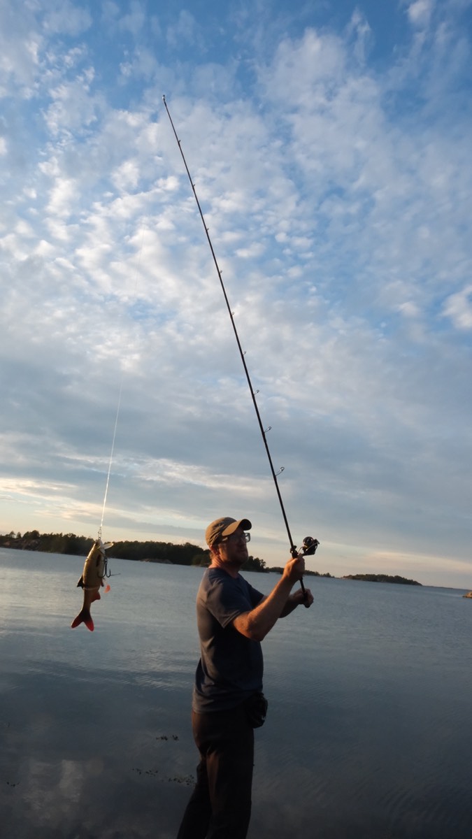 Angler mit Fisch im Abendlicht